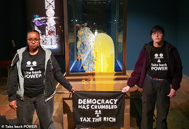 104503121-15487579-The_pair_unfurled_a_banner_saying_democracy_has_crumbled_tax_the-m-3_1769078857814.jpg