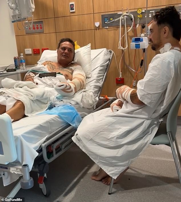 Un padre y un hijo luchan por sus vidas después de que supuestamente fueron asesinados a puñaladas en su propio patio trasero en una aterradora disputa vecinal.