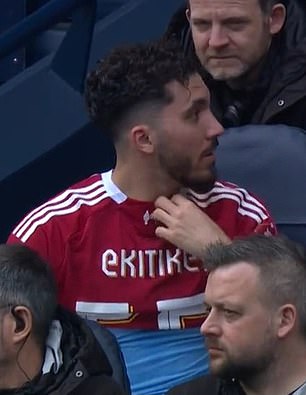 A Rayan Cherki se le pide que se QUITE la camiseta del Liverpool después de irritar al cuerpo técnico del Manchester City al usarla en el banco después de ser sustituido por su compañero suplente Hugo Ekitike en un extraño incidente: los fanáticos golpean al delantero de los Rojos.