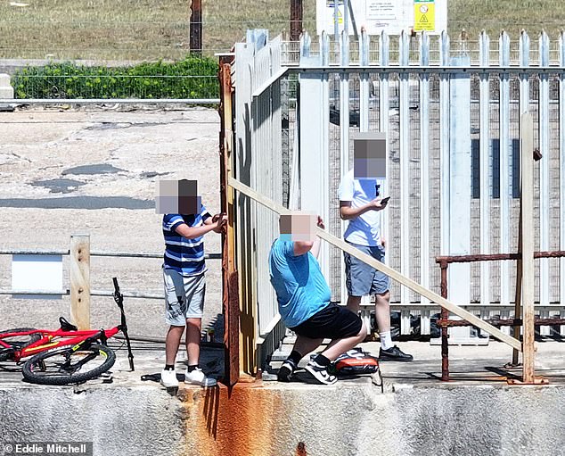 Batalla por una playa de propiedad francesa… en Sussex: momento en el que los adolescentes escalan una valla para refrescarse en el mar, después de que una organización impidiera que los lugareños la usaran durante 18 años