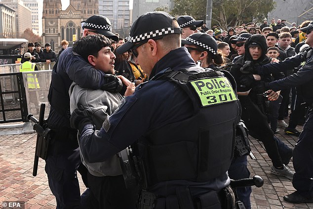 El caos estalla en la Plaza de la Federación cuando la policía se lleva a rastras a un aficionado mientras los Socceroos van al descanso con un marcador de 0-0 contra Paraguay después de dominar la posesión en un apretado choque de la Copa del Mundo.