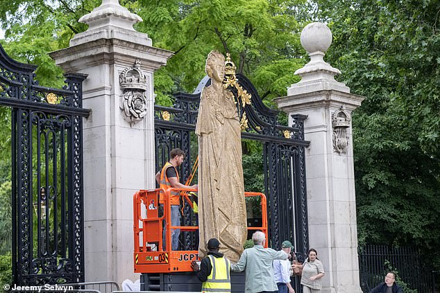 Los transeúntes sostienen bambú con una figura de cartón gigante de la reina Isabel en St James’s Park