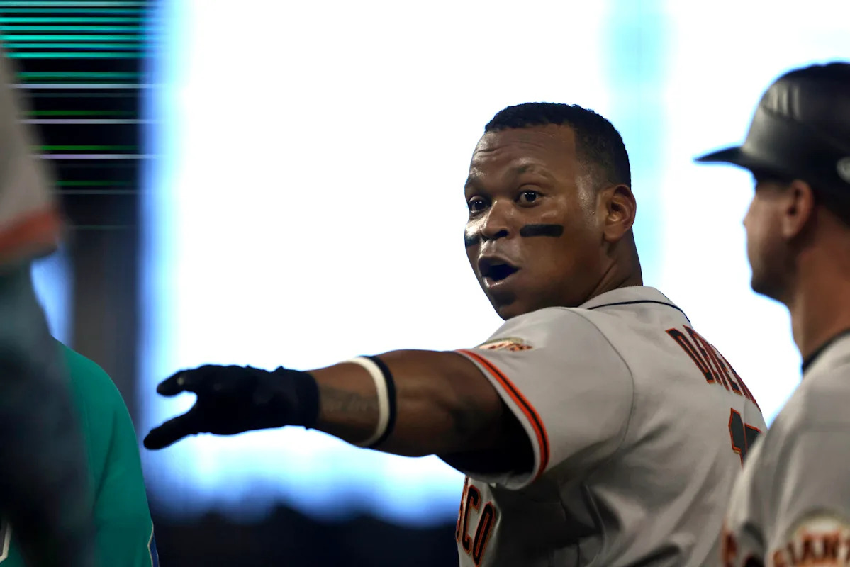 Rafael Devers, de los Gigantes, intenta repetidamente desviar al corredor emergente después de llegar a 1B como carrera del empate en la novena.